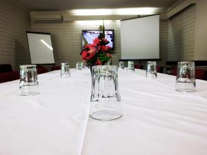 a white table topped with two white vases filled with flowers at Edinburgh Motor Inn in Warragul