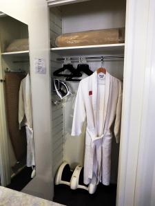 a walk in closet with a white suit and shoes at Edinburgh Motor Inn in Warragul