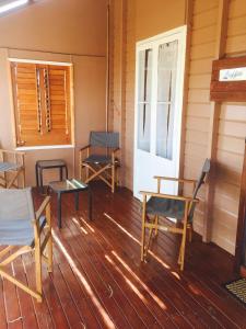 a porch of a house with chairs and a door at Cottage on Cork -Laffin Cottage in Winton