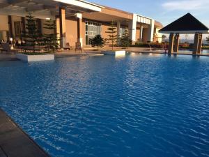 une grande piscine d'eau bleue devant un bâtiment dans l'établissement Relaxing Wind, à Tagaytay