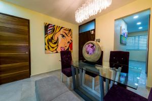 a dining room with a glass table and purple chairs at Once21 Apartment in Guadalajara