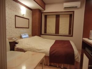 a room with two beds and a table and a window at Hotel Hyper Noah (Adult Only) in Sakai