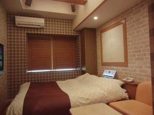 a bedroom with a bed and a window at Hotel Hyper Noah (Adult Only) in Sakai