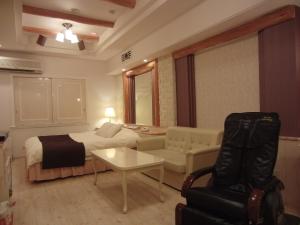 a hotel room with a bed and a couch and a table at Hotel Hyper Noah (Adult Only) in Sakai