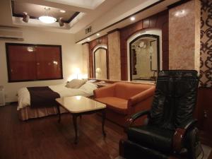 a hotel room with a bed and a chair at Hotel Hyper Noah (Adult Only) in Sakai