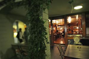 ein Restaurant mit einem Tisch und einer grünen Efeu-Wand in der Unterkunft Hotel Restaurant Schwert Thun in Thun