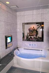 a bath tub in a bathroom with a tv at Hotel Hyper Noah (Adult Only) in Sakai