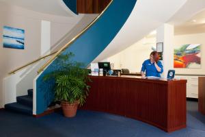 a woman standing at a counter in an office at Admiral Motel Bunbury in Bunbury