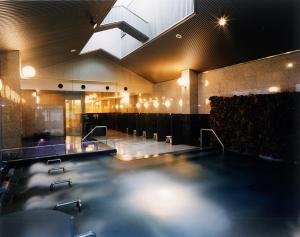 a large swimming pool in a large room with chairs at Yuno Yado Shoei in Kyoto
