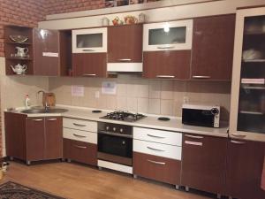 a kitchen with brown cabinets and a sink and a microwave at ShymHostle in Shymkent