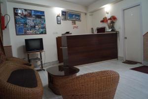 a waiting room with a reception desk and wicker chairs at Hotel Renam in Gangtok