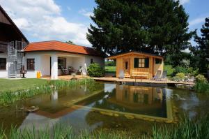 una casa con un estanque frente a una casa en Pension Wolkenreich, en Oberhaag
