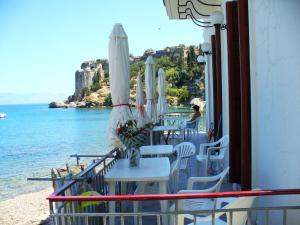 a group of tables with umbrellas and the ocean at Xenios Zeus Rooms in Koroni