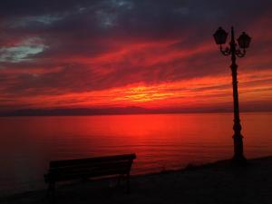 a bench next to a street light and a sunset at Marathon Eco Stay in Marathon
