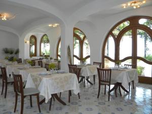a dining room with tables and chairs and windows at Hotel Parco Conte in Casamicciola Terme