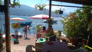 a group of people sitting on a beach near the water at 'By the Lake' Apartments in Ohrid