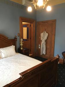 a bedroom with a bed and a robe hanging on a door at Freeman On Ford in Beechworth
