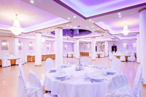 un salón de banquetes con mesas blancas y sillas blancas en Hotel Politański, en Rybnik