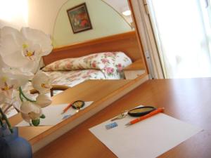 espejo reflejo de una habitación con cama y escritorio en Hotel Olimpia, en Bellaria-Igea Marina