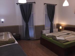 duas camas num quarto com cortinas pretas em Elvis Guesthouse em Budapeste