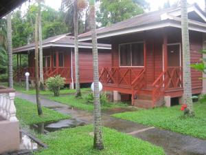 a red house with palm trees in front of it at Eastana Cherating Beach Resort in Cherating +21 photos