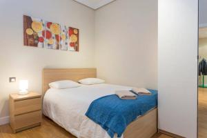 a bedroom with a bed with a blue blanket at Puerta del Sol Center in Madrid