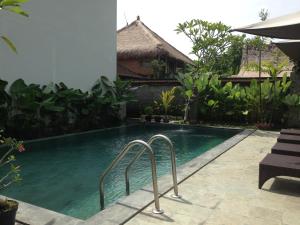 a swimming pool in front of a villa at Nugraha Guest House 2 in Ubud