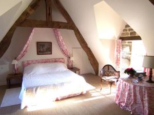 una camera da letto con letto in mansarda di Manoir de Kerguéréon a Ploubezre