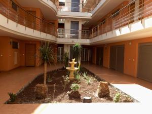 a courtyard of an apartment building with a fountain at Hola Apartments 1-30 in Playa de San Juan +7 photos