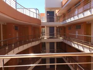an empty building with balconies and stairs in a building at Hola Apartments 1-30 in Playa de San Juan