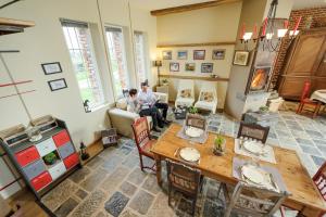 two people sitting in a living room with a table at Les Chambres de Ribeaufontaine in Dorengt