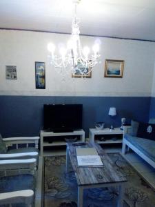 ein Wohnzimmer mit einem Sofa und einem Kronleuchter in der Unterkunft Kyrön Loma in Kyrö
