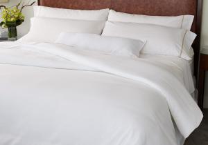 a white bed with white sheets and pillows at Glen Waverley Apartment in Glen Waverley