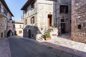 un vicolo in un antico edificio in pietra con scala di Bed and Breakfast A casa delle Fate ad Assisi