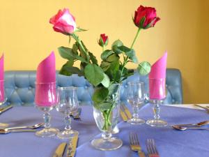 a table with roses in a vase with pink candles at Hotel le Dauphin in Ajaccio