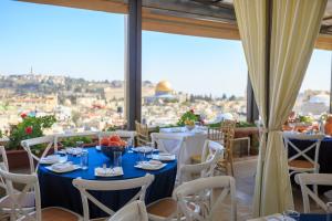 ein Restaurant mit Tischen und Stühlen und Stadtblick in der Unterkunft Hashimi Hotel in Jerusalem