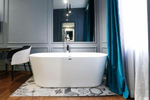 eine weiße Badewanne im Bad mit Spiegel in der Unterkunft Saint B Boutique Hotel STB in Rom