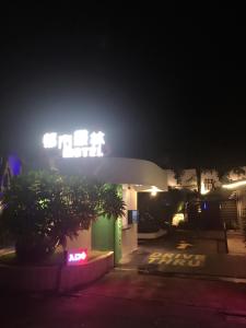 una gasolinera por la noche con una señal encendida en Jungle City Motel, en Chiayi