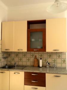 a kitchen with white cabinets and a sink at Appartamento la Garzetta in Venice