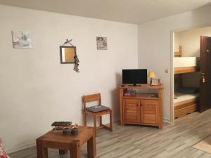 sala de estar con TV y mesa de madera en Studio Cabine Les Balcons du Soleil en Font Romeu Odeillo Via