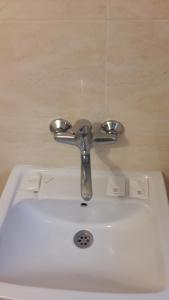 um lavatório de casa de banho com uma torneira de prata em Magnolia Guest house em Haskovo