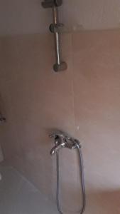 La salle de bains est pourvue d'une douche avec un robinet. dans l'établissement Magnolia Guest house, à Haskovo