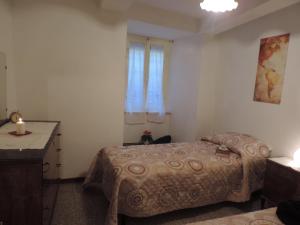 a bedroom with a bed and a dresser and a window at La Casa Dei Nonni in Cortona