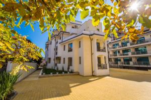 a building with yellow leaves on a brick road at Апартамент за гости Villa Ravda in Ravda