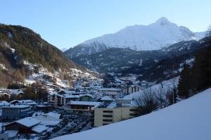 una ciudad cubierta de nieve con montañas en el fondo en Ferienhof Riml, en Sölden