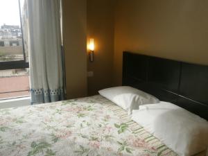 a bedroom with a large bed with a large window at Strenua - Las Quintanas in Trujillo