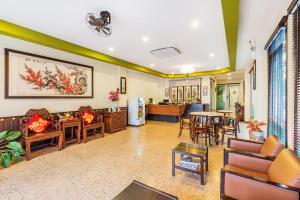ein Wohnzimmer mit Möbeln und ein Esszimmer in der Unterkunft Le Hua Hotel in Phuket