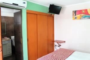 ein Schlafzimmer mit einem Bett und einem TV an der Wand in der Unterkunft Hotel Samaña in Arica