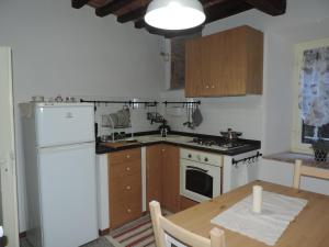 コルトーナにあるLa Casa Dei Nonniのキッチン(白い冷蔵庫、木製テーブル付)