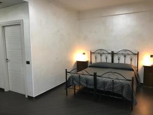 1 dormitorio con 1 cama, 2 lámparas y puerta en Hotel Toscano, en Tarsia